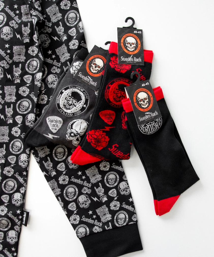 F&auml;rjestad BK merchandise utlagd p&aring; en gr&auml;ddvit hoodie: ett vit- och gr&ouml;nf&auml;rgat golfklubbsfodral, en randig mugg, ett litet snapsglas i metall och ett par randiga strumpor