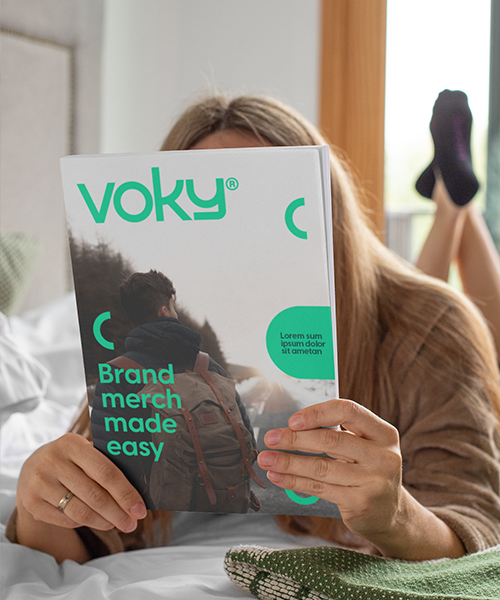 Person som ligger i sängen och håller i ett Voky-magasin