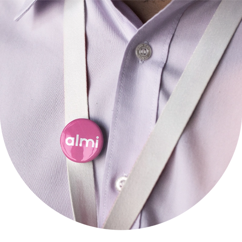 Rosa Almi-pin på axelrem över ljusrosa skjorta